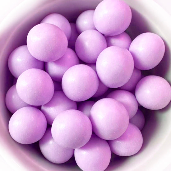 Close-up of purple spherical candies in a white bowl