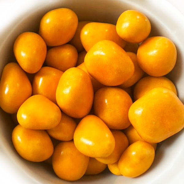 Close-up of orange candies in a white bowl